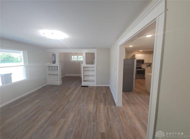 spare room featuring baseboards and wood finished floors