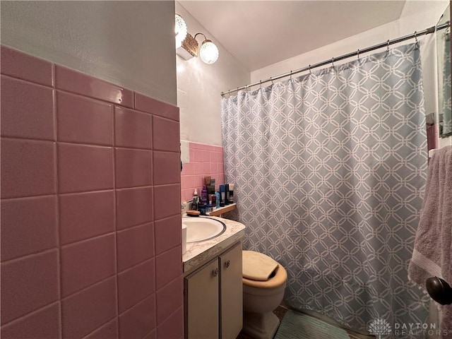 bathroom featuring toilet, a shower with curtain, vanity, and tile walls