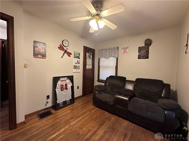 home theater room with visible vents, ceiling fan, baseboards, and wood finished floors