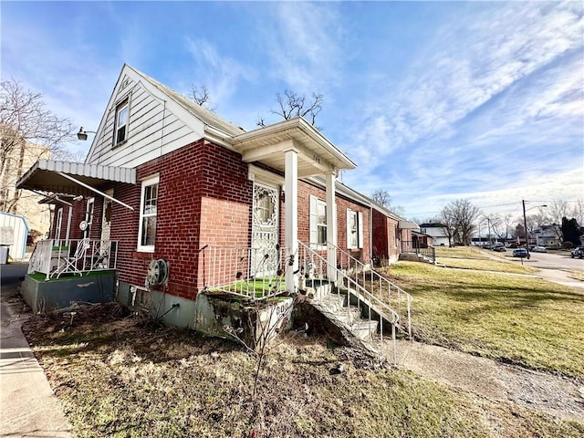 view of property exterior with brick siding and a lawn