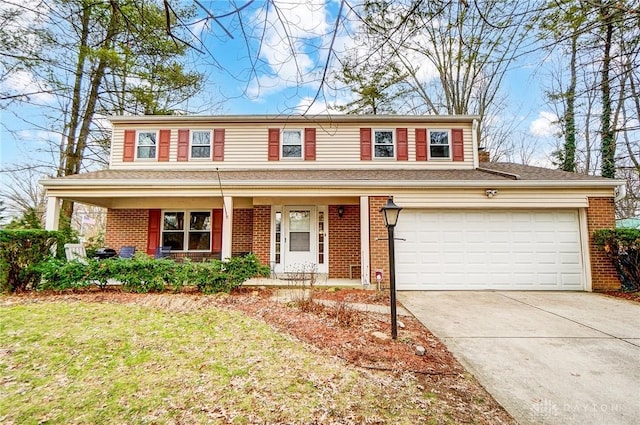 traditional-style home with covered porch, concrete driveway, brick siding, and a front yard