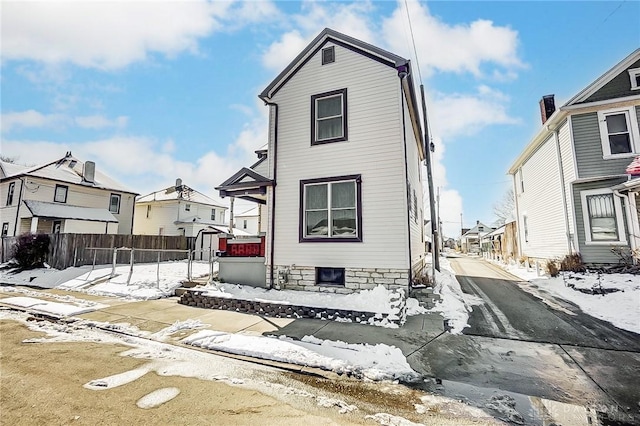 view of front facade with a residential view and fence