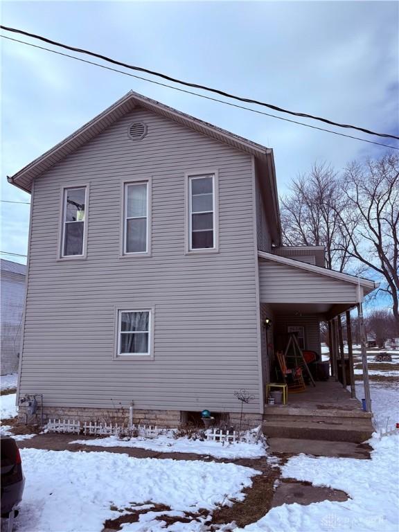 view of snow covered exterior featuring covered porch