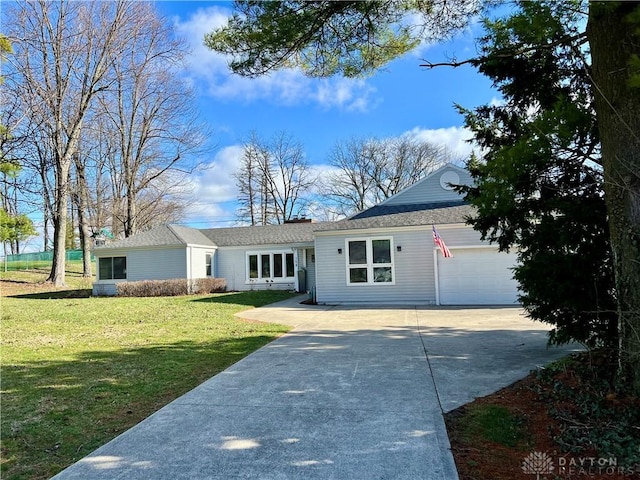 ranch-style home featuring a front yard, an attached garage, and driveway