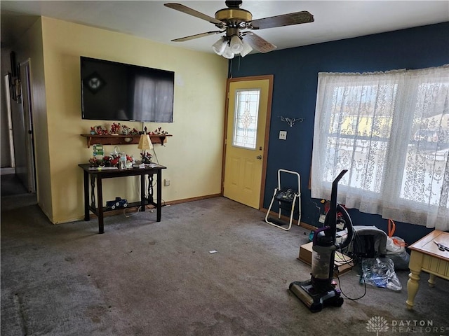 foyer entrance with carpet flooring, ceiling fan, and baseboards