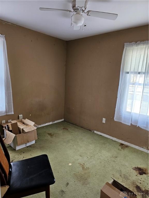 empty room with a ceiling fan, carpet flooring, and baseboards