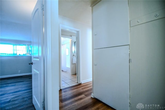 corridor with baseboards and dark wood-style flooring