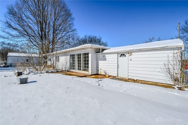 view of snow covered rear of property