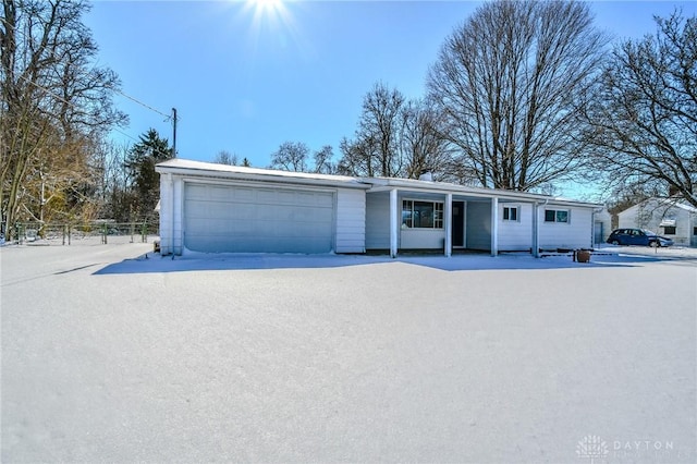 ranch-style home with a garage and fence