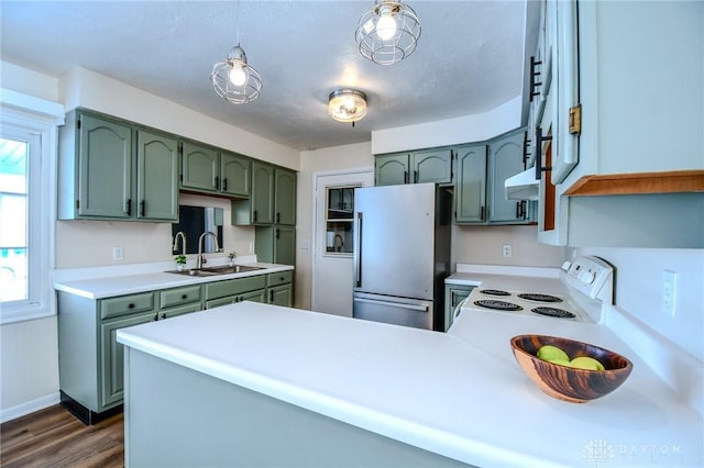 kitchen featuring white electric stove, freestanding refrigerator, light countertops, green cabinets, and a sink