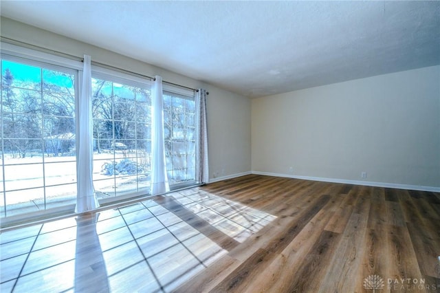 unfurnished room featuring wood finished floors and baseboards