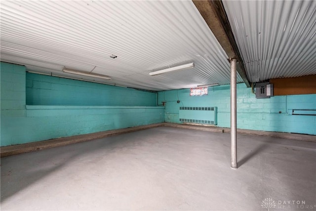 basement with radiator heating unit and concrete block wall