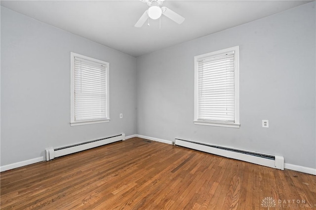 spare room with a baseboard radiator, baseboards, ceiling fan, and wood finished floors