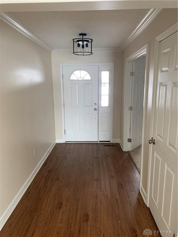 doorway to outside featuring ornamental molding, dark wood-type flooring, and baseboards