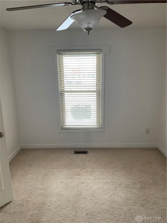 unfurnished room with ceiling fan, baseboards, visible vents, and light colored carpet