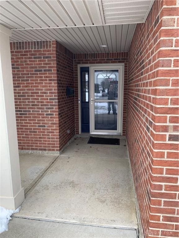 doorway to property with brick siding