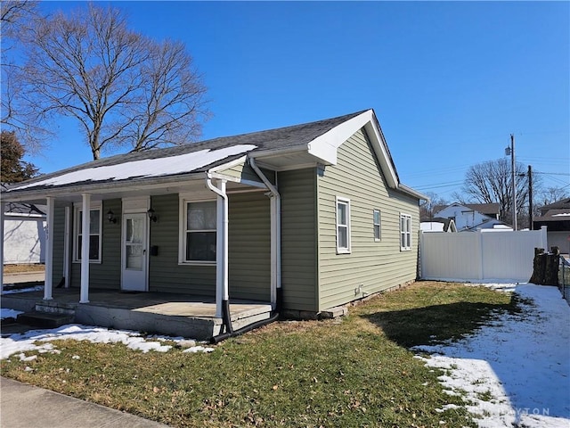 view of front of property with a porch, fence, and a lawn