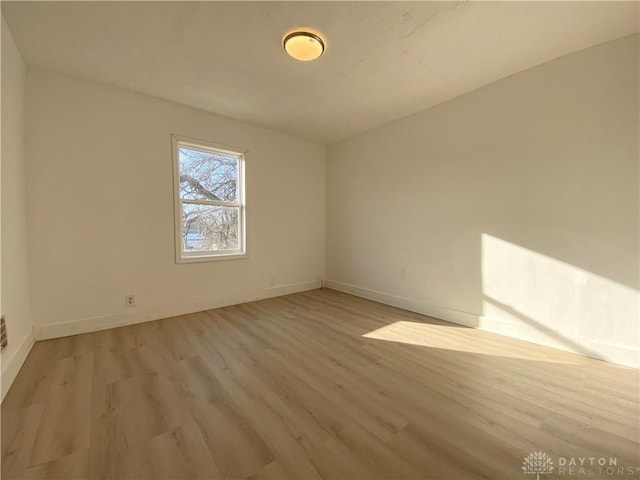 spare room with light wood-style floors and baseboards