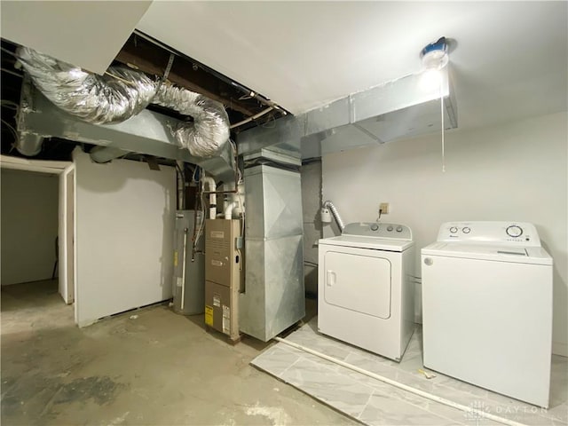 unfinished basement featuring heating unit, electric water heater, and independent washer and dryer