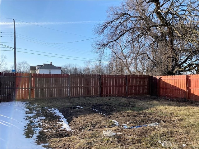 yard layered in snow with a fenced backyard