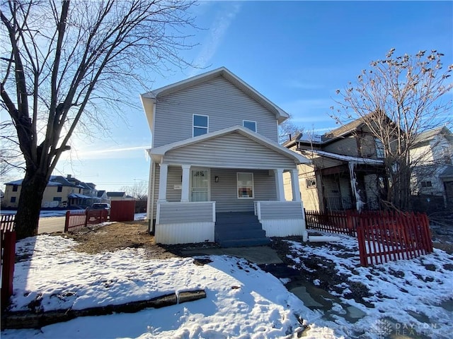 american foursquare style home with covered porch and fence