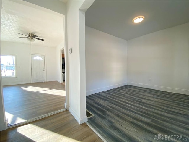 foyer featuring dark wood-style floors, ceiling fan, and baseboards