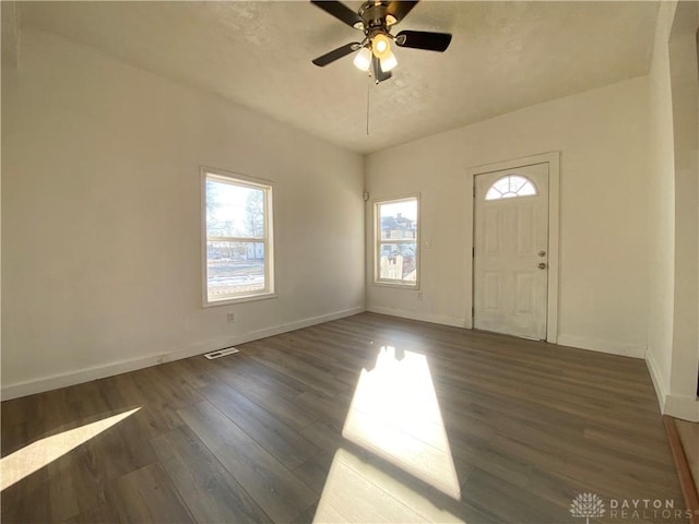 foyer entrance with a textured ceiling, visible vents, a ceiling fan, baseboards, and dark wood-style floors