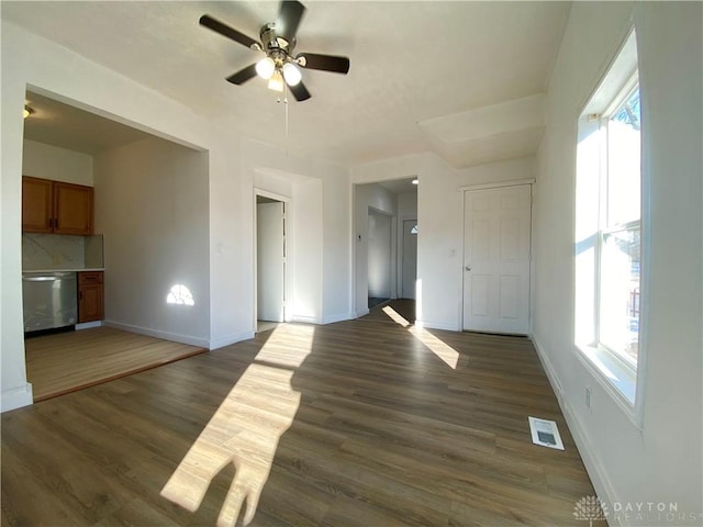 empty room featuring dark wood-style floors, visible vents, and baseboards