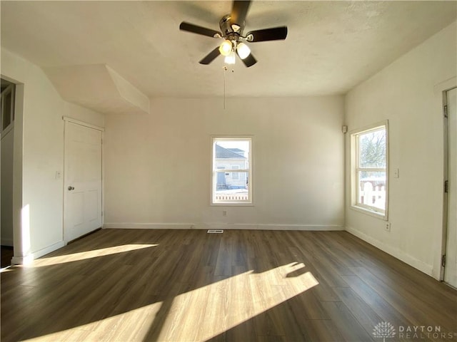 unfurnished bedroom with ceiling fan, dark wood-style flooring, and baseboards