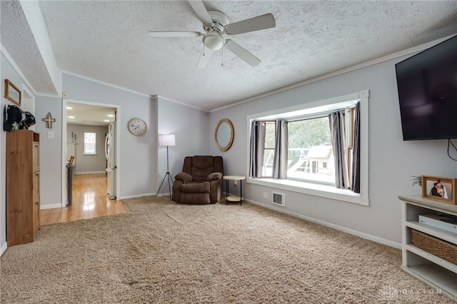 sitting room featuring carpet, visible vents, ornamental molding, vaulted ceiling, and a textured ceiling