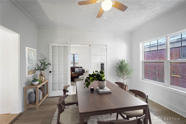 dining area featuring ornamental molding, dark wood-style flooring, and baseboards