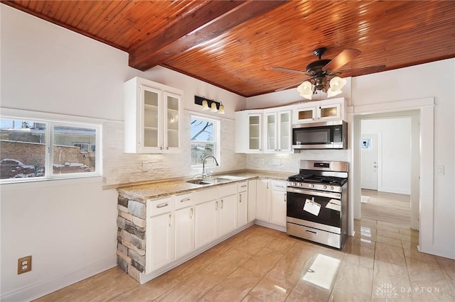 kitchen featuring glass insert cabinets, white cabinetry, stainless steel appliances, and a sink