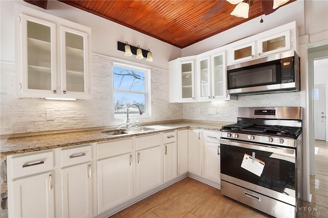 kitchen featuring stainless steel appliances, white cabinets, glass insert cabinets, and a sink