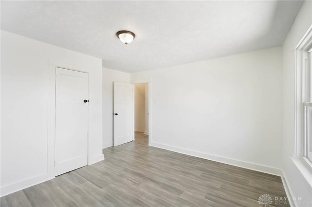 unfurnished room with baseboards and wood finished floors