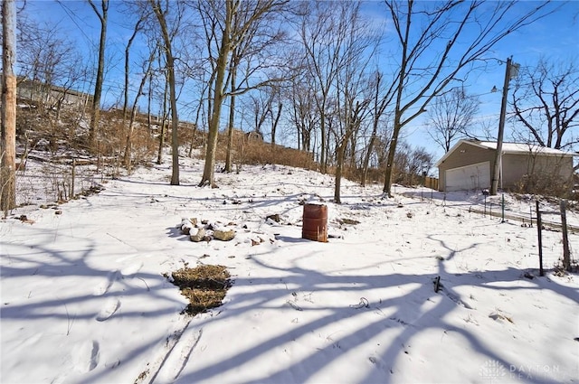 snowy yard featuring a detached garage