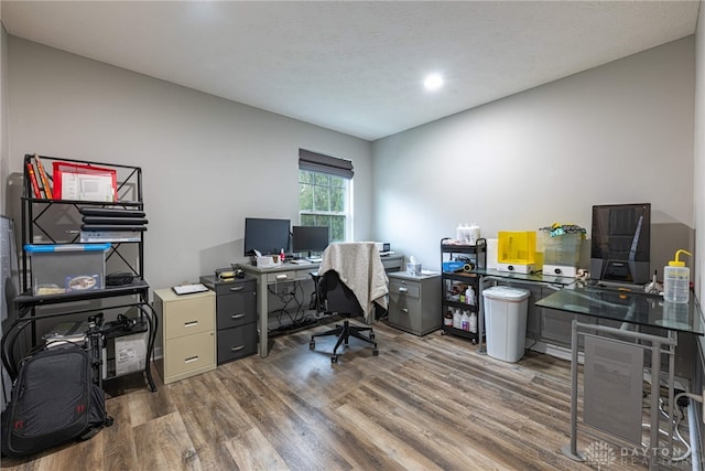 home office with a textured ceiling and dark wood-type flooring