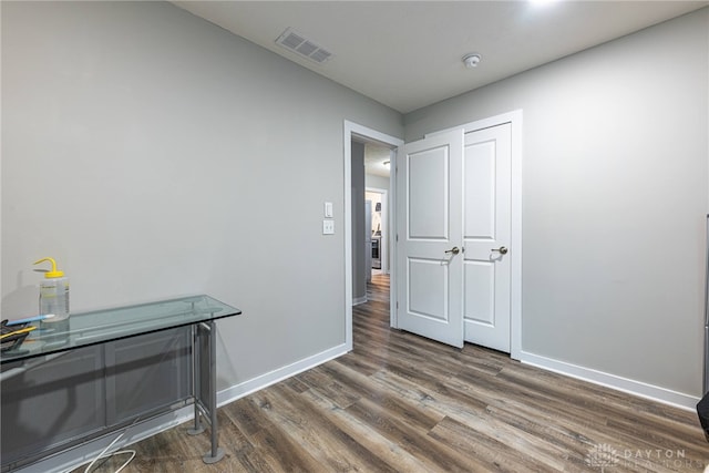 interior space featuring dark wood-style floors, visible vents, and baseboards