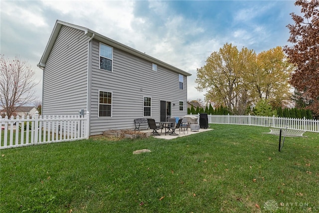 back of house with a yard, a patio area, and a fenced backyard