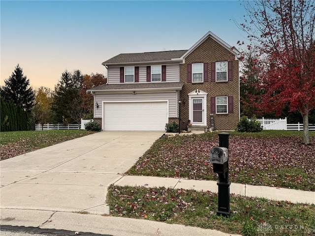 traditional-style home with a garage, concrete driveway, brick siding, and fence