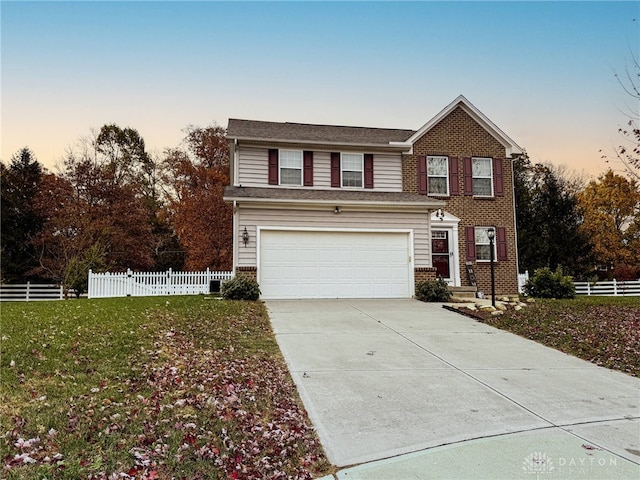 traditional-style house with an attached garage, brick siding, fence, driveway, and a yard