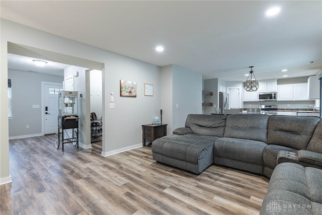 living area with light wood-type flooring, baseboards, and recessed lighting