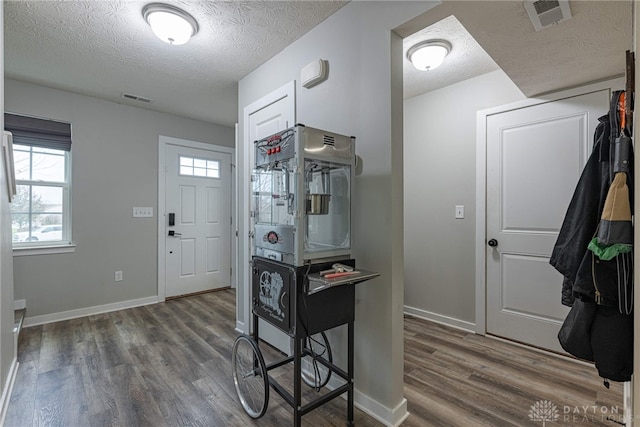 entrance foyer with dark wood-type flooring, visible vents, and baseboards