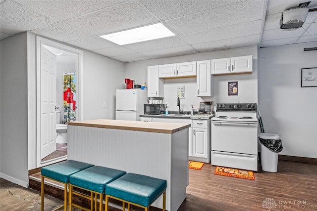 310 E Maple Ave, Miamisburg, OH 45342 - kitchen with white appliances, a paneled ceiling, a breakfast bar area, white cabinetry, and butcher block countertops