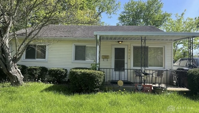 bungalow-style house featuring a porch, a shingled roof, and a front yard