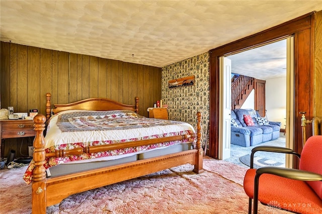 bedroom with carpet floors and wood walls