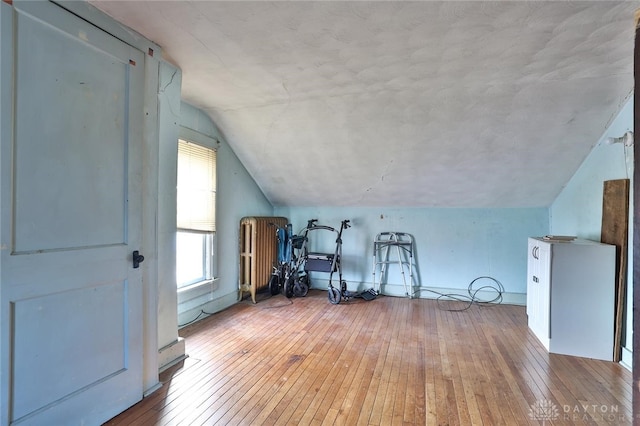 bonus room featuring lofted ceiling and light wood-style flooring