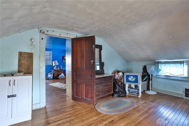 bonus room with vaulted ceiling and wood finished floors