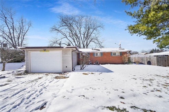 view of front of home featuring brick siding, an attached garage, and fence