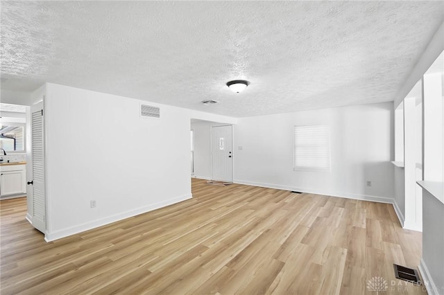 empty room featuring baseboards, visible vents, and light wood-style floors