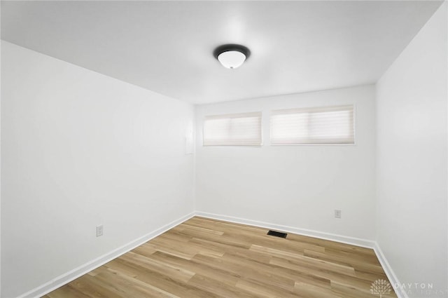 spare room featuring baseboards, visible vents, and light wood finished floors